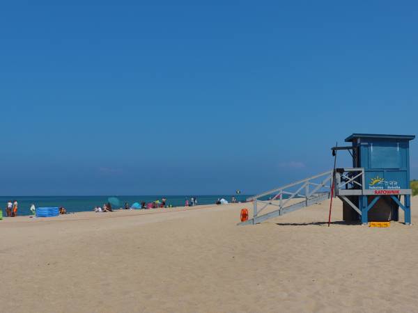 Szeroka piaszczysta plaża strzeżona przez ratowników