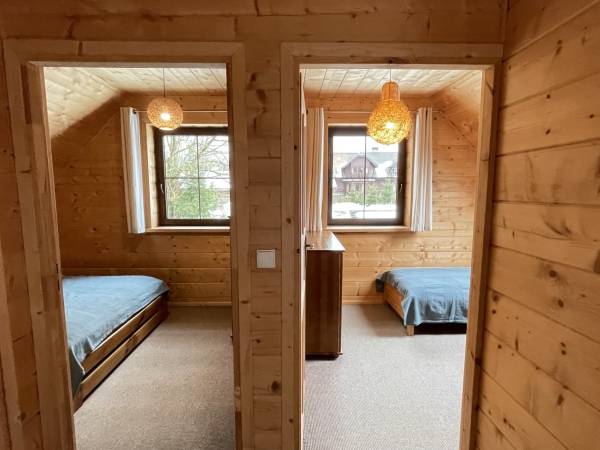 Widok na pokoje z korytarza na piętrze Apartamentu Drewno.