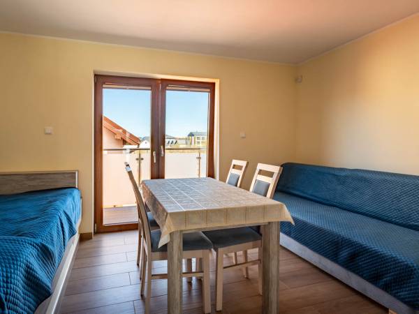 Duże łóżko i kanapa rozkładana na piętrze z wyjściem na balkon