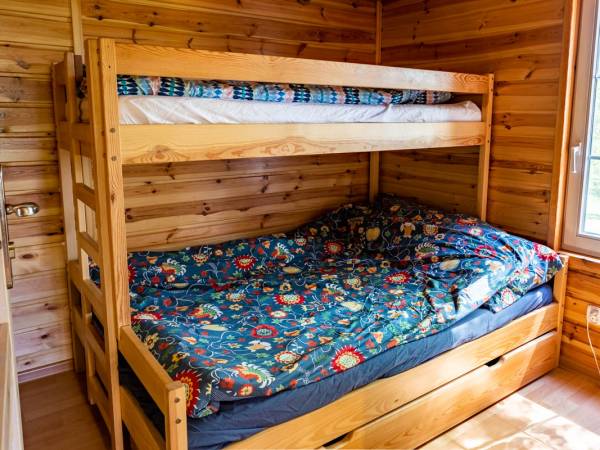 Sypialnia w domku drewnianym. Trzyosobowe łózko piętrowe.