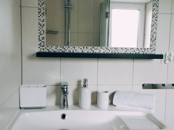 Umywalka na parterze w łazience z prysznicem.