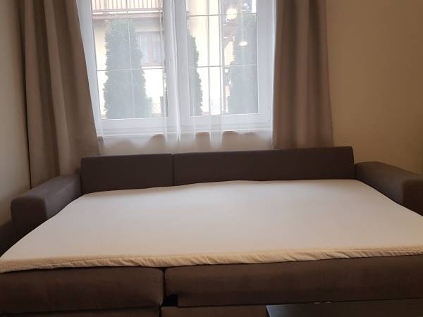 rozkładane sofy w salonie wyposażone w dodatkowe materace dla większego komfortu snu