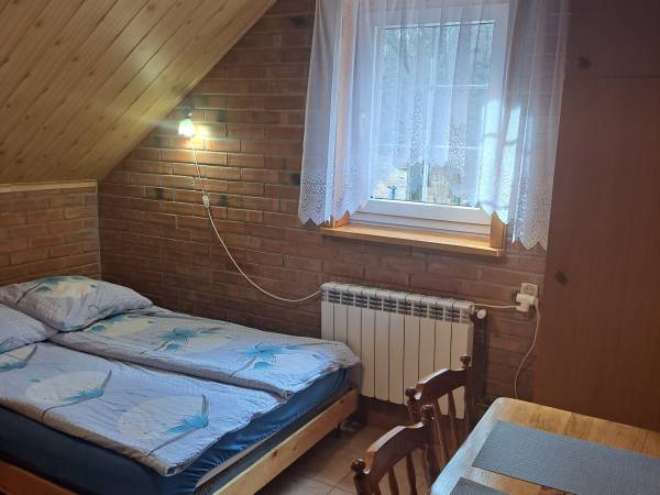 Pokój dwuosobowy w żółtym budynku z jednym podwójnym łóżkiem z łazienką z zapleczem kuchennym 