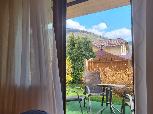  widok z pokoju 3-osobowego z podwójną sofą i wyjściem do ogrodu