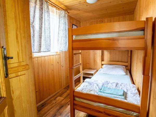 W dwóch domkach 4-osobowych 2-pokojowych są w drugim pokoju łóżka piętrowe