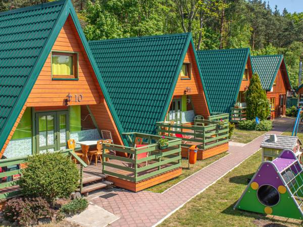domki z tarasami z grillami zielone z widokiem na plac zabaw 