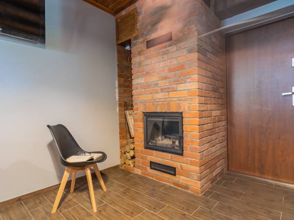 Kominek w salonie w apartamencie 10 osobowym 