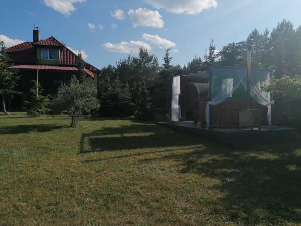 widok z ogrodu na pensjonat oraz saunę i jacuzzi. 