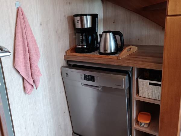 Kącik ze zmywarką, ekspresem i czajnikiem.