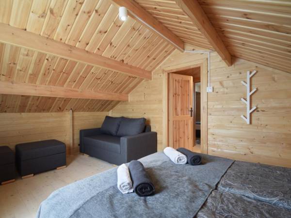 Sypialnia z łóżkiem małżeńskim i dwuosobową sofą. Domek "trzy"